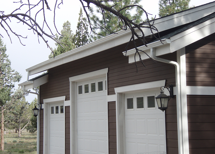 The three-car garage features three white rollup doors and of various sizes